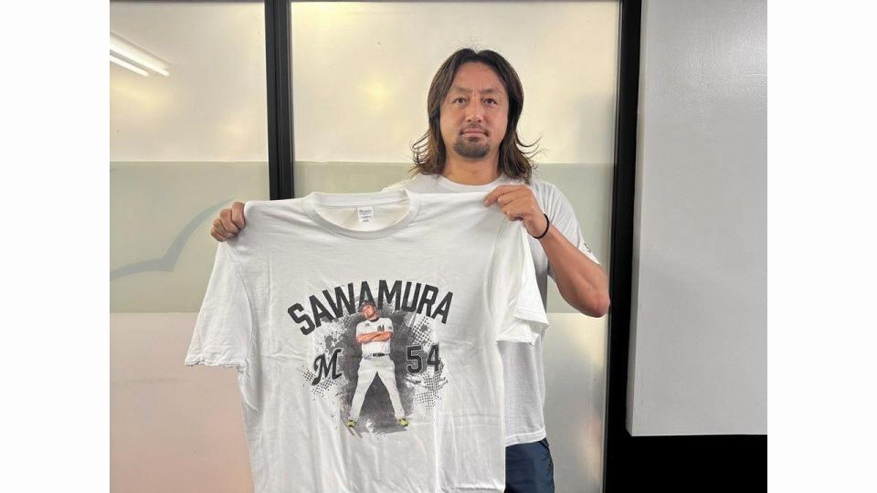 　腕組みポーズＴシャツを手に持つ沢村（球団提供）