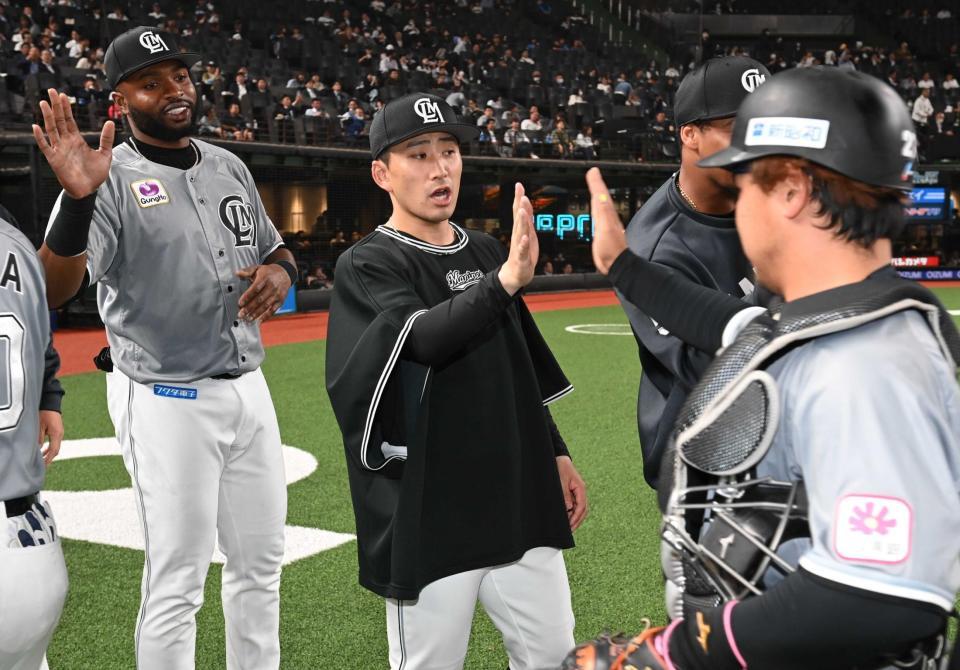 　ナインを迎える小島（撮影・金田祐二）