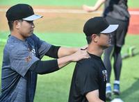 　大城卓（左）から肩をもまれる中川（撮影・佐々木彰尚）