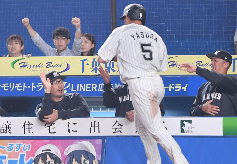 　５回、岡の中前適時打で二塁から生還した安田（手前）とタッチを交わす吉井監督（左）＝撮影・開出牧