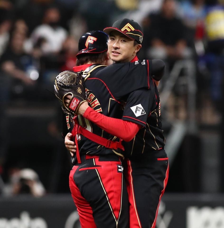 　完封勝利をあげ、清水（左）と抱き合う上沢（撮影・中島達哉）