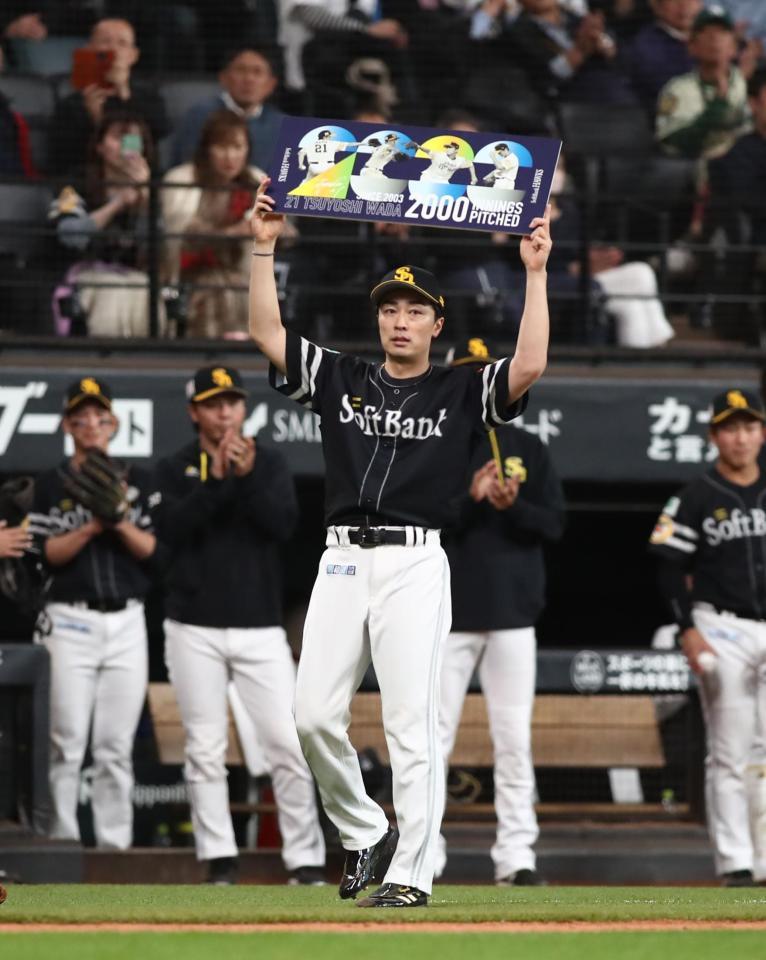 　２回を投げ終え、通算２０００投球回を達成し、記念ボードを掲げる和田（撮影・中島達哉）
