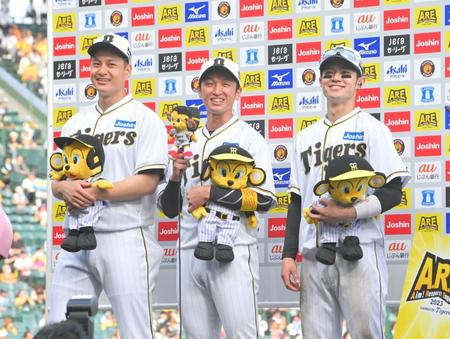 お立ち台に上がってヒーローインタビューを受け、笑顔を見せる（左から）大竹、近本、中野（撮影・立川洋一郎）