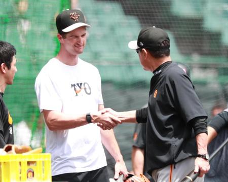 　２７日の阪神戦で好投したグリフィン（左）と握手する原監督