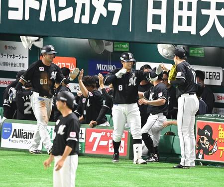 　１回、左越え２ランを放ち、佐々木朗（右端）らナインの出迎えを受ける中村奨（右から２人目）