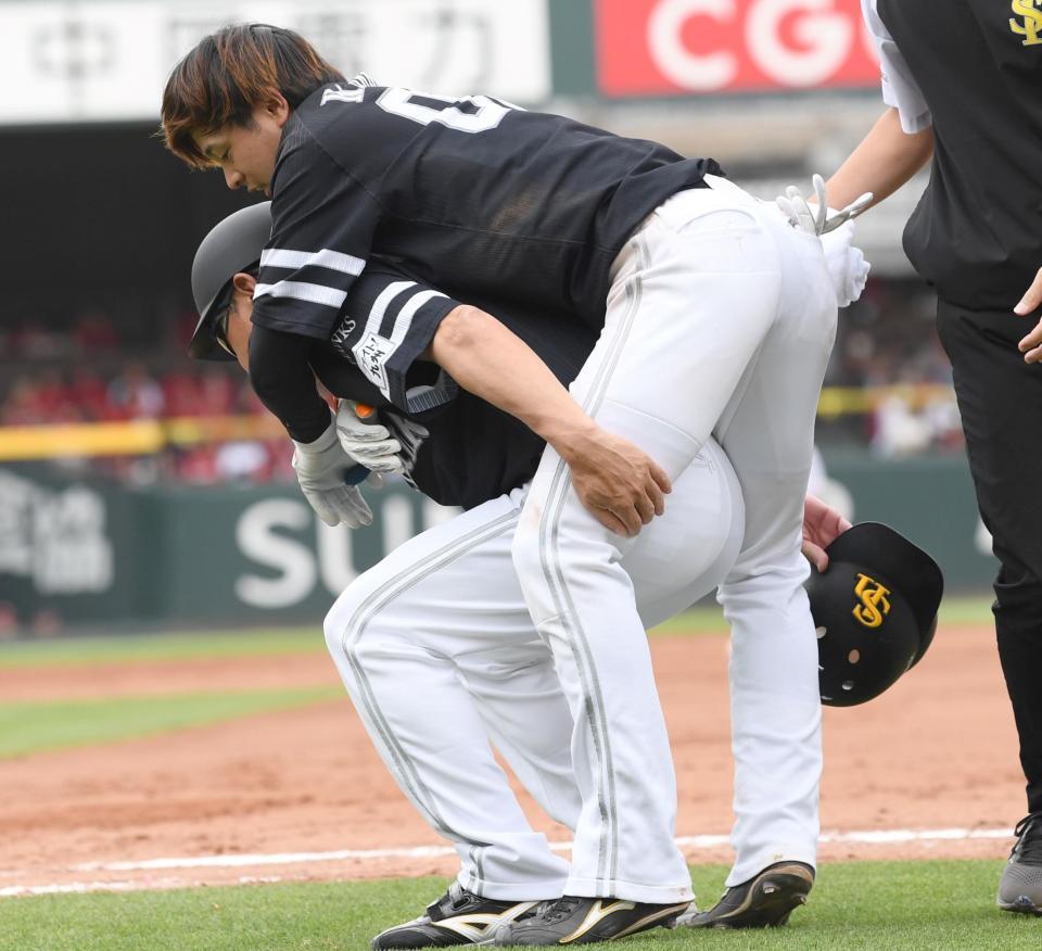 　松山コーチにおんぶされてベンチへ向かう川瀬＝４日
