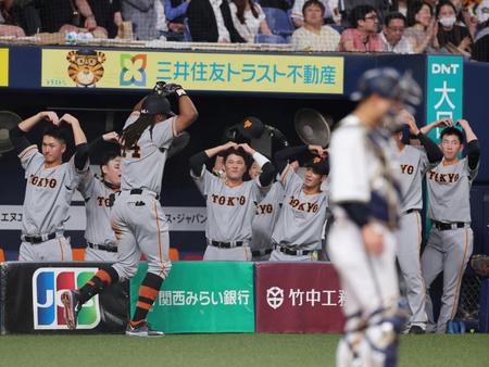 　６回、ソロを放ったウォーカーを迎える坂本（中央）ら巨人ナイン（撮影・山口登）