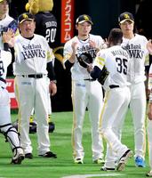 ７回無失点で４勝目を挙げ、モイネロ（手前）からウイニングボールを受け取る東浜（中央）。左は藤本監督