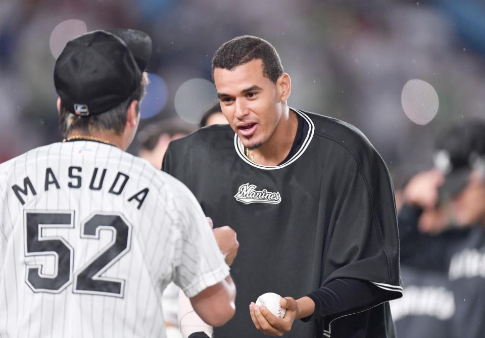 　最終回を抑えた益田（手前）からウイニングボールを受け取るカスティーヨ（撮影・開出牧）