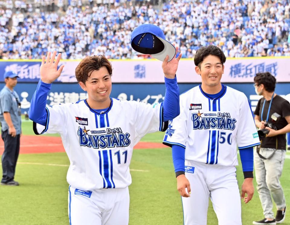 　完封で７勝目を挙げた東（左）は、山本とともにファンの声援に応える