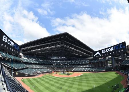 　試合前、屋根が開いた球場と、練習する日本ハムナイン（撮影・中島達哉）