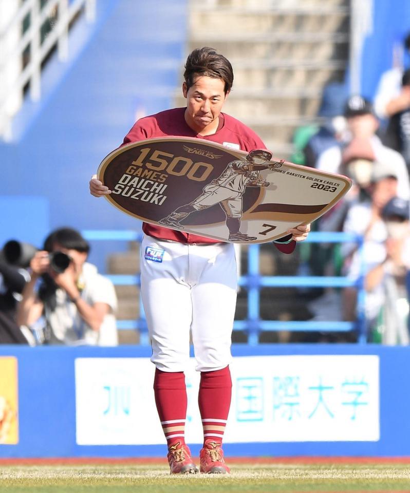 　通算１５００試合出場を達成しボードを手に頭を下げる鈴木大（撮影・開出牧）