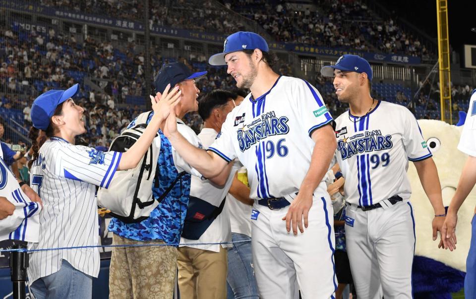 　ファンとタッチするバウアー（撮影・佐藤厚）