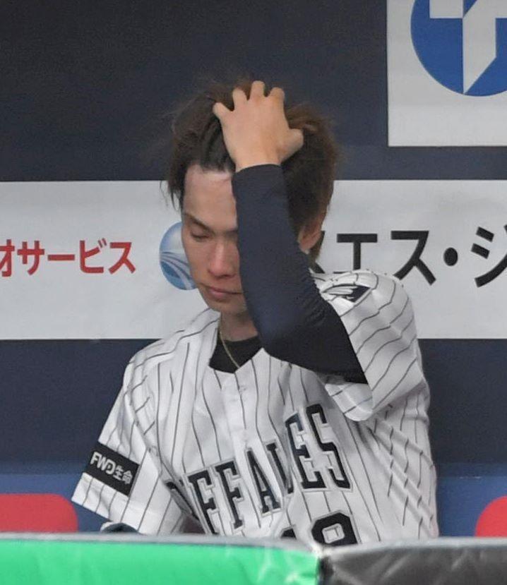 　５回途中、交代を告げられてベンチに腰かけた山岡は髪をかき上げる（撮影・北村雅宏）