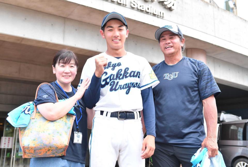 　初戦を突破し笑顔でガッツポーズを決める東京学館浦安・谷佳亮（中央）。右は本紙評論家の父・谷佳知氏、左は母・亮子さん