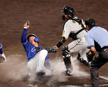 　１０回、大島の右前打で送球が乱れ一塁走者の福永も生還する（撮影・山口登）