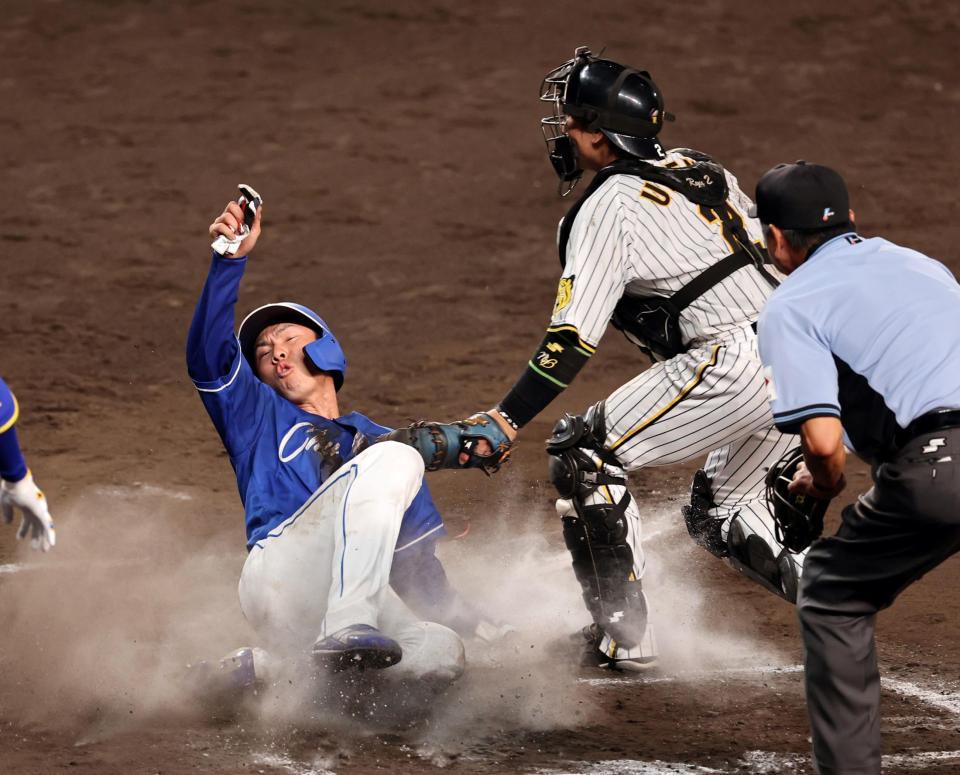 　１０回、大島の右前打で送球が乱れ一塁走者の福永も生還する（撮影・山口登）