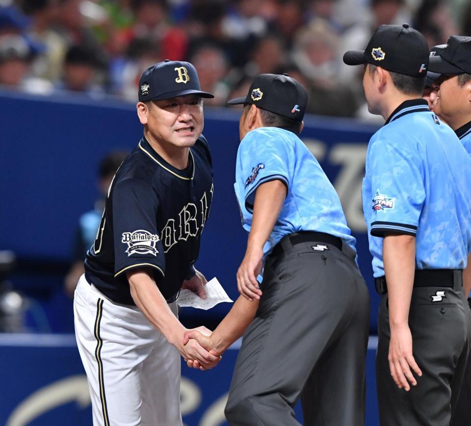 　白井審判を引っ張りながら握手を交わす中嶋監督（撮影・中田匡峻）