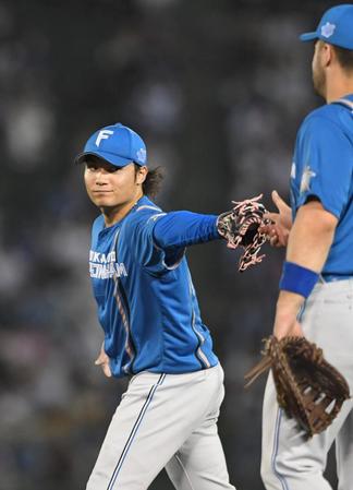 　４回、宗を一ゴロに打ち取り、マルティネス（右）とタッチを交わす伊藤（撮影・北村雅宏）