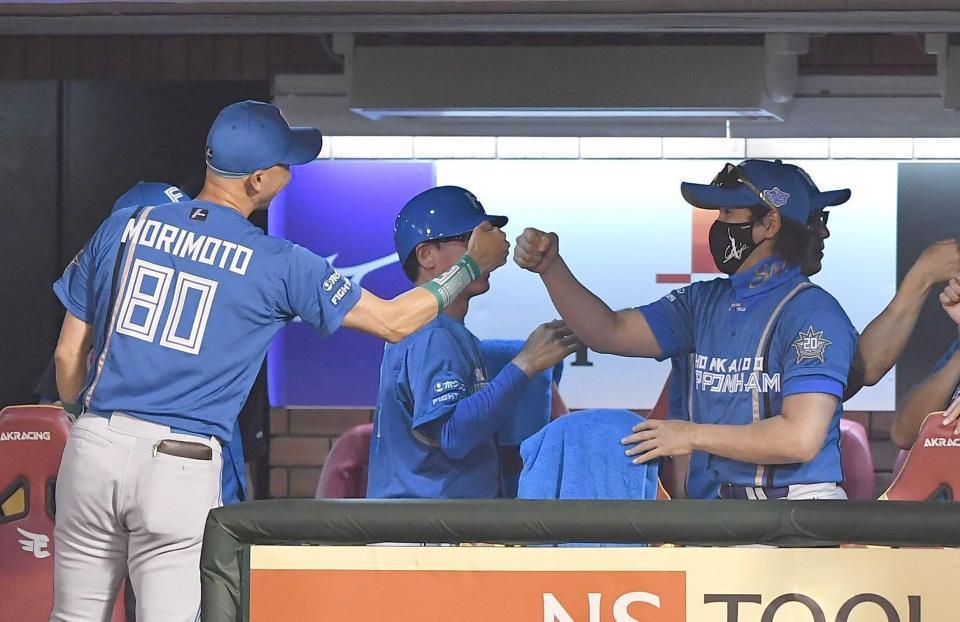 　連敗を脱出し森本コーチ（左）とグータッチを交わす新庄監督（撮影・開出牧）