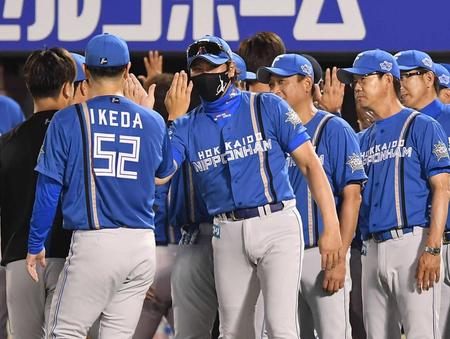 　連敗脱出しナインとタッチを交わす新庄（中央）＝撮影・開出牧