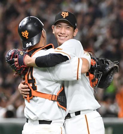 　熱投１４９球の完投で１０勝目を挙げ、大城卓（左）と抱き合う戸郷（撮影・佐藤厚）