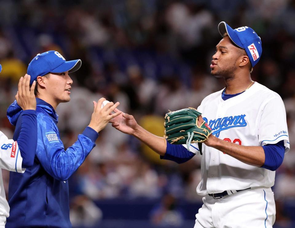 　移籍後初勝利の記念球をマルティネス（右）から受け取る斎藤