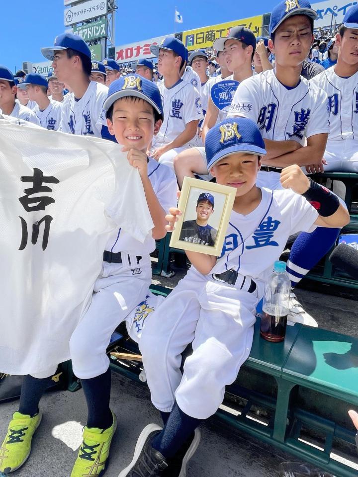 　昨年１１月に亡くなった吉川孝成さんの練習着を持つ悠之輔さん（左）と写真を持つ寛太さん