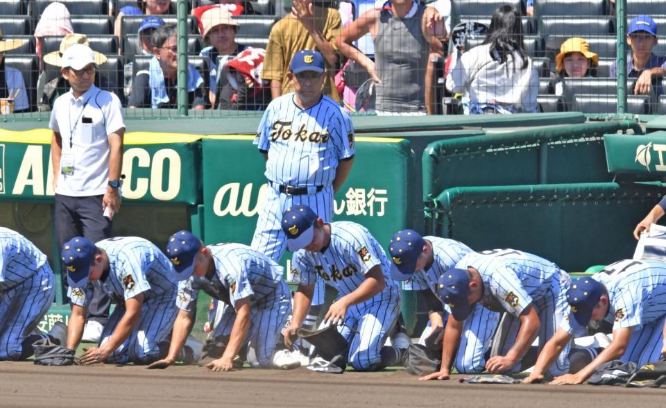 　専大松戸に敗れ、土を集める選手たちを見つめる東海大甲府・村中秀人監督（撮影・中田匡峻）