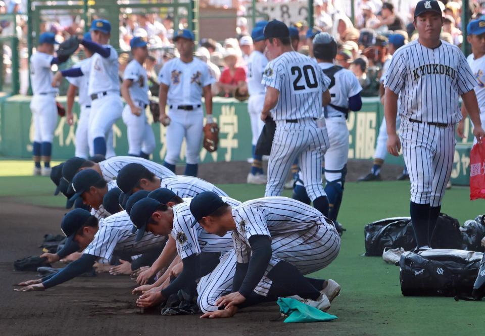 　甲子園の土を集める九州国際大付ナイン。佐倉（右端）は土をとらず（撮影・石湯恒介）