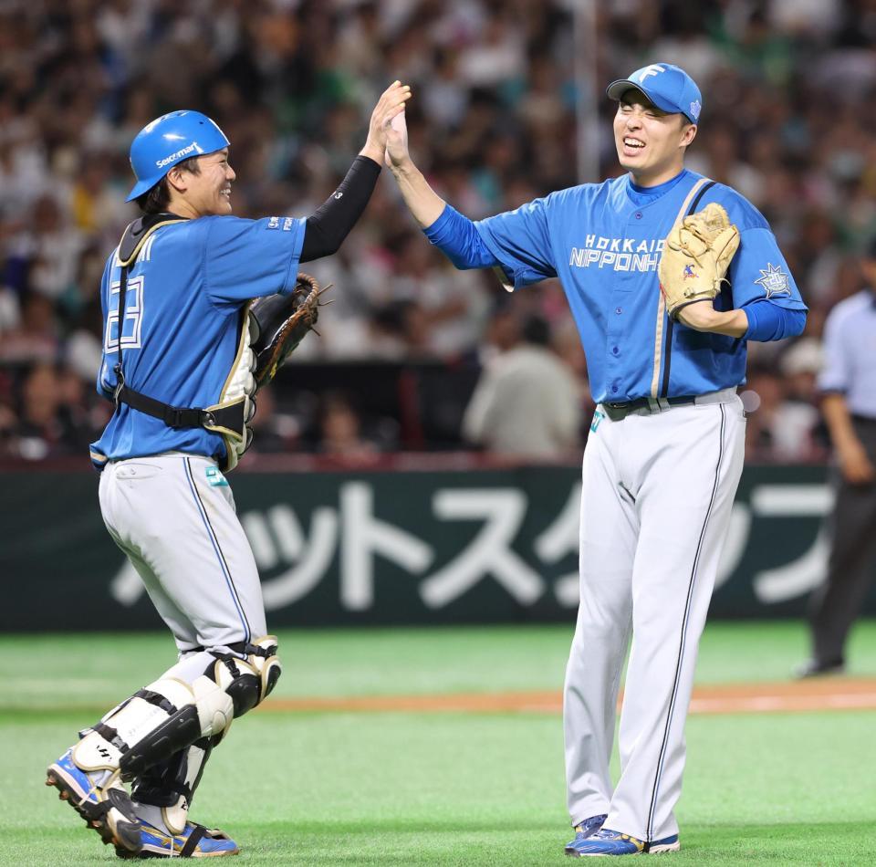 　９回を締め、伏見（左）とハイタッチする田中正