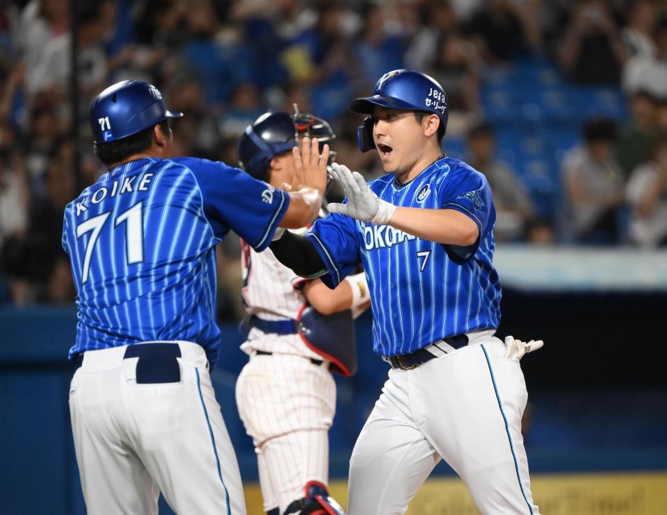 　７回、２ランを放ち生還して小池コーチ（左）に迎えられる佐野（撮影・堀内翔）