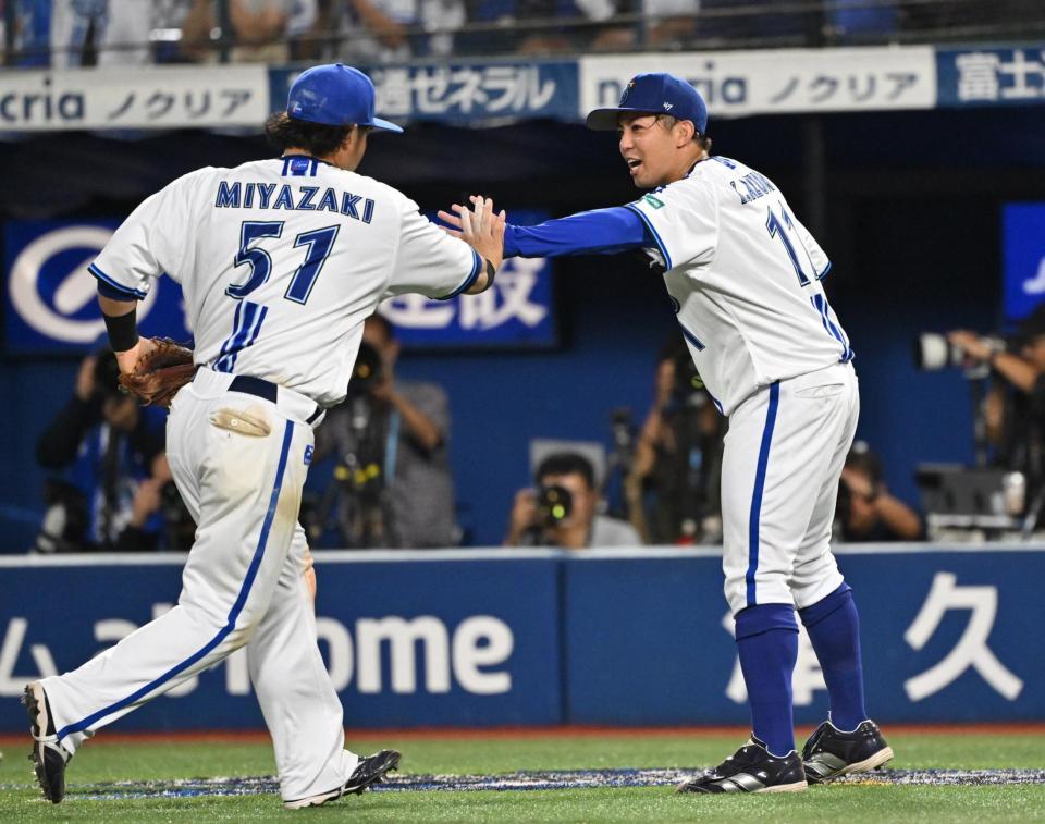 ７回、代打ミエセスを三ゴロ併殺打に仕留め、好守の宮崎（左）とタッチを交わす東