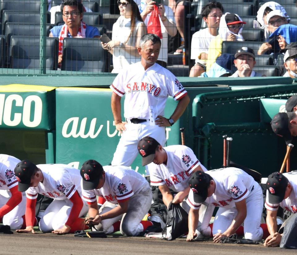 　土を集める選手を見つめるおかやま山陽・堤尚彦監督（後方中央）＝撮影・中田匡峻