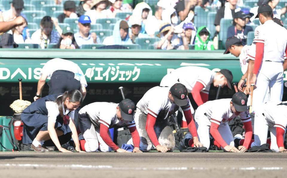 　試合に敗れ、土を拾うおかやま山陽ナイン（撮影・石井剣太郎）