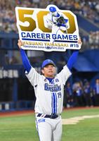 　５００試合登板を達成し、ボードを掲げる山崎（撮影・西岡正）