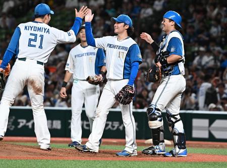 　完封勝利を挙げ、清宮（左端）とタッチを交わす伊藤