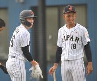 　１回、大阪桐蔭・前田悠伍（右）に手伝われながら打撃の準備をする慶応・丸田湊斗（撮影・伊藤笙子）