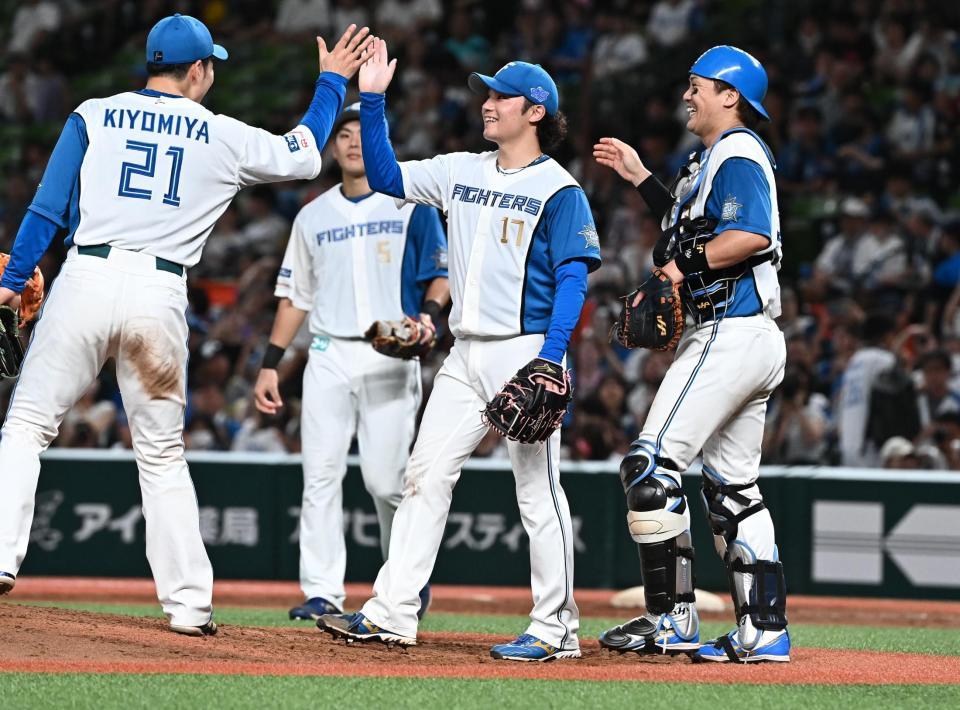 　完封勝利を挙げ、清宮（左端）とタッチを交わす伊藤