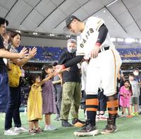 　阪神に勝利し、ファンとタッチする岡本和（撮影・吉澤敬太）