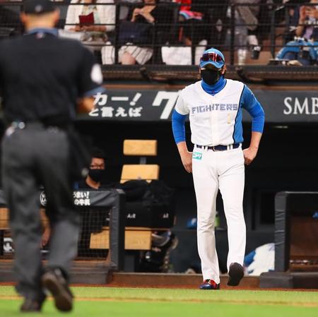 　８回、選手交代を告げにベンチを出る新庄監督（撮影・中島達哉）