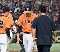 　６回表開始前の投球練習中に右手を気にする菅野（中央）