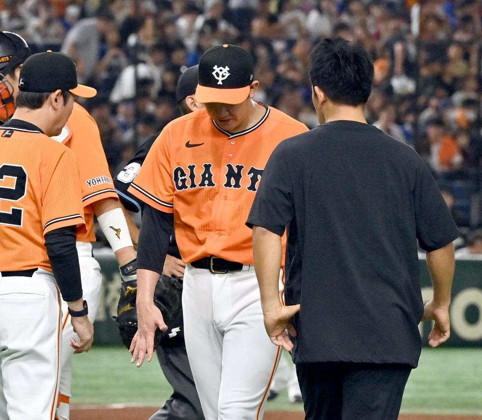 　６回表開始前の投球練習中に右手を気にする菅野（中央）