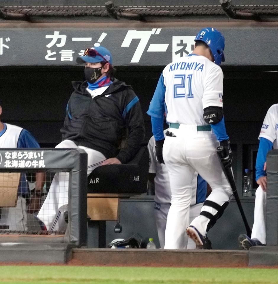 　６回、空振りの三振に倒れベンチに戻る清宮。左は新庄監督