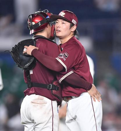 　９回、代打・田村を三振に仕留めた松井裕（右）はほっとした表情を浮かべ太田と抱き合う（撮影・開出牧）