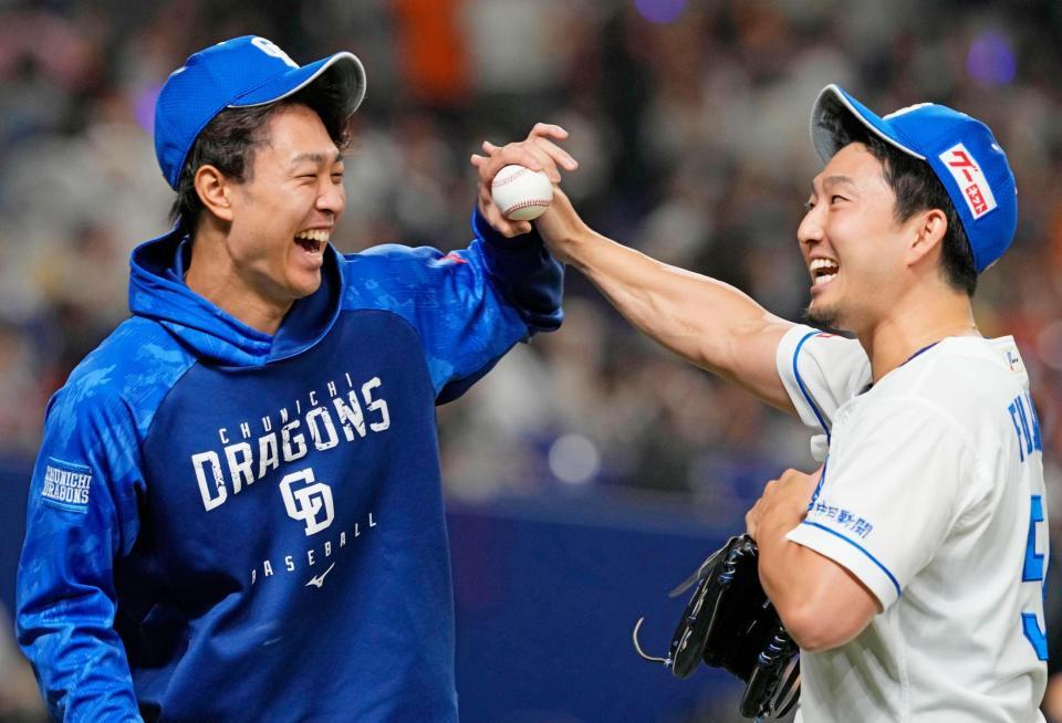 　巨人に勝利し記念ボールを譲り合う、６勝目を挙げた高橋宏（左）と３季ぶりセーブの藤嶋