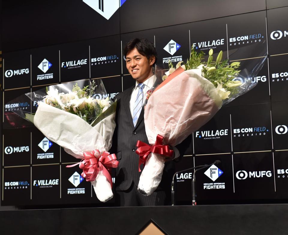 　花束を手に記念撮影に応じる木村（撮影・中島達哉）