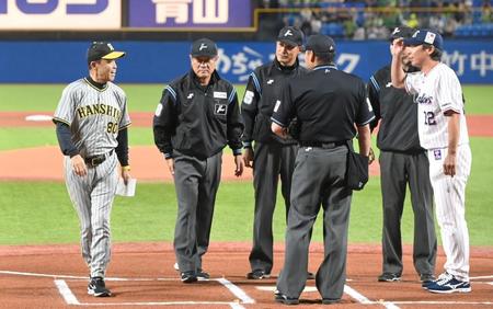 　試合前のメンバー表交換を終え、笑顔で言葉を交わす岡田監督（左）と高津監督（撮影・高部洋祐）