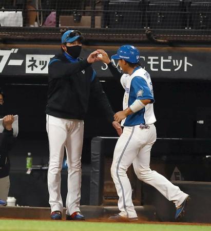 　６回、プロ初本塁打を放った田宮（右）にボールを渡す新庄監督（撮影・中島達哉）