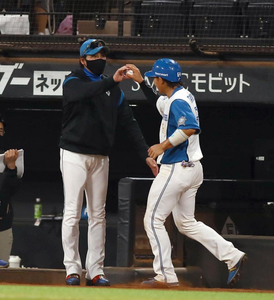 　６回、プロ初本塁打を放った田宮（右）にボールを渡す新庄監督（撮影・中島達哉）